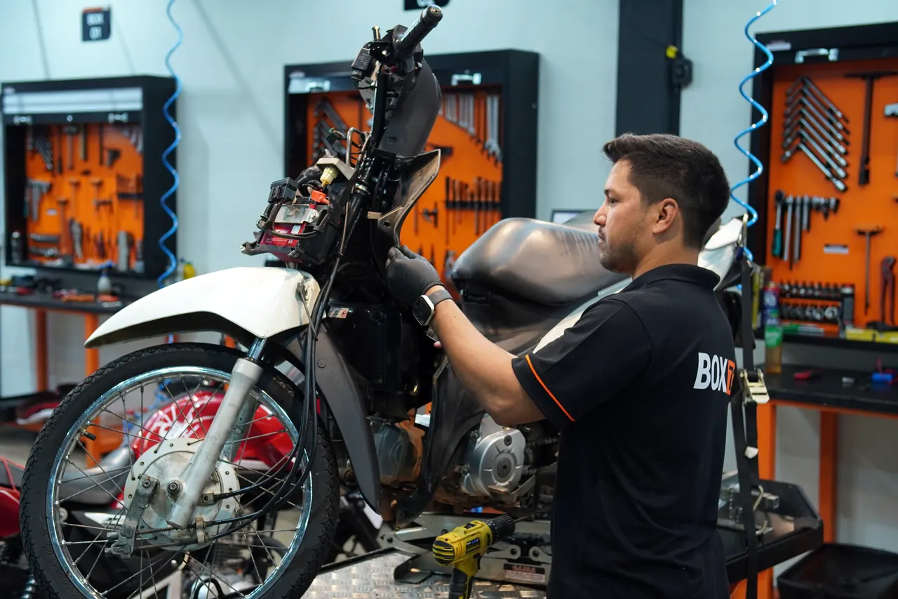 Mecânico da Box 73 trabalhando em uma moto no elevador